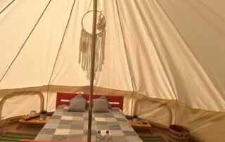 Interior view of a glamping cabin with a cozy bed