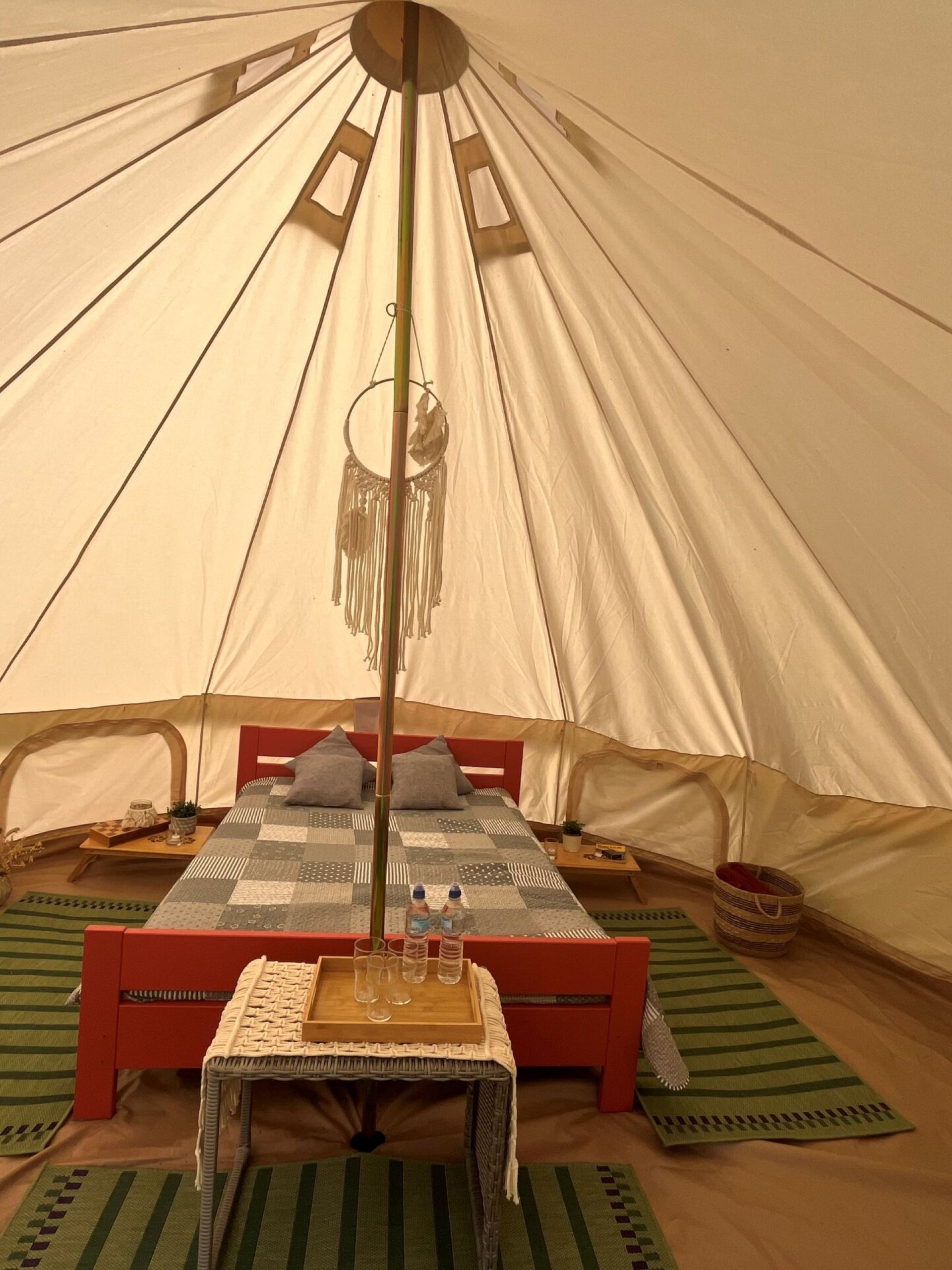 Interior view of a glamping cabin with a cozy bed